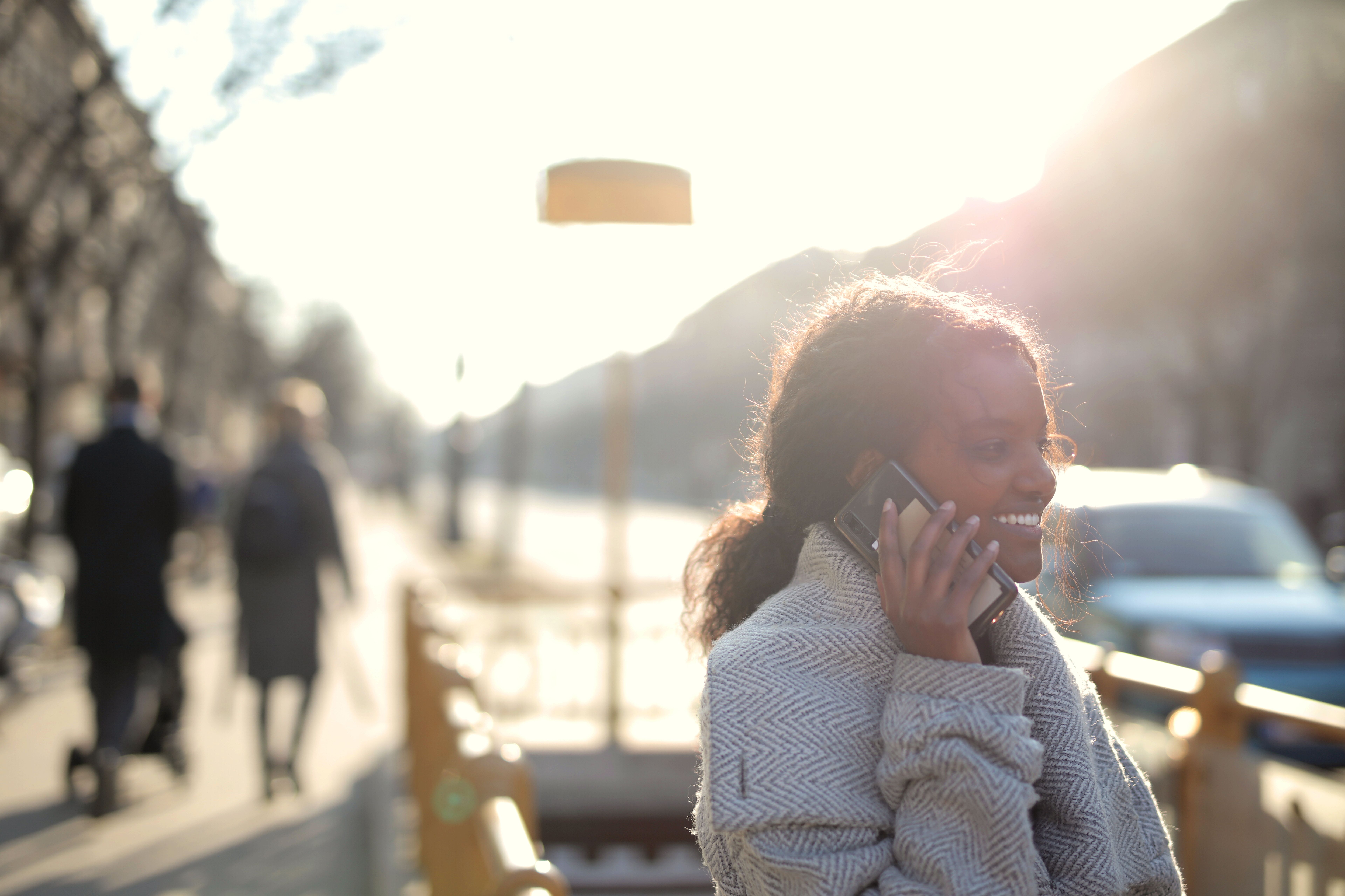 A person walking outdoors, in conversation on the phone, at dusk
