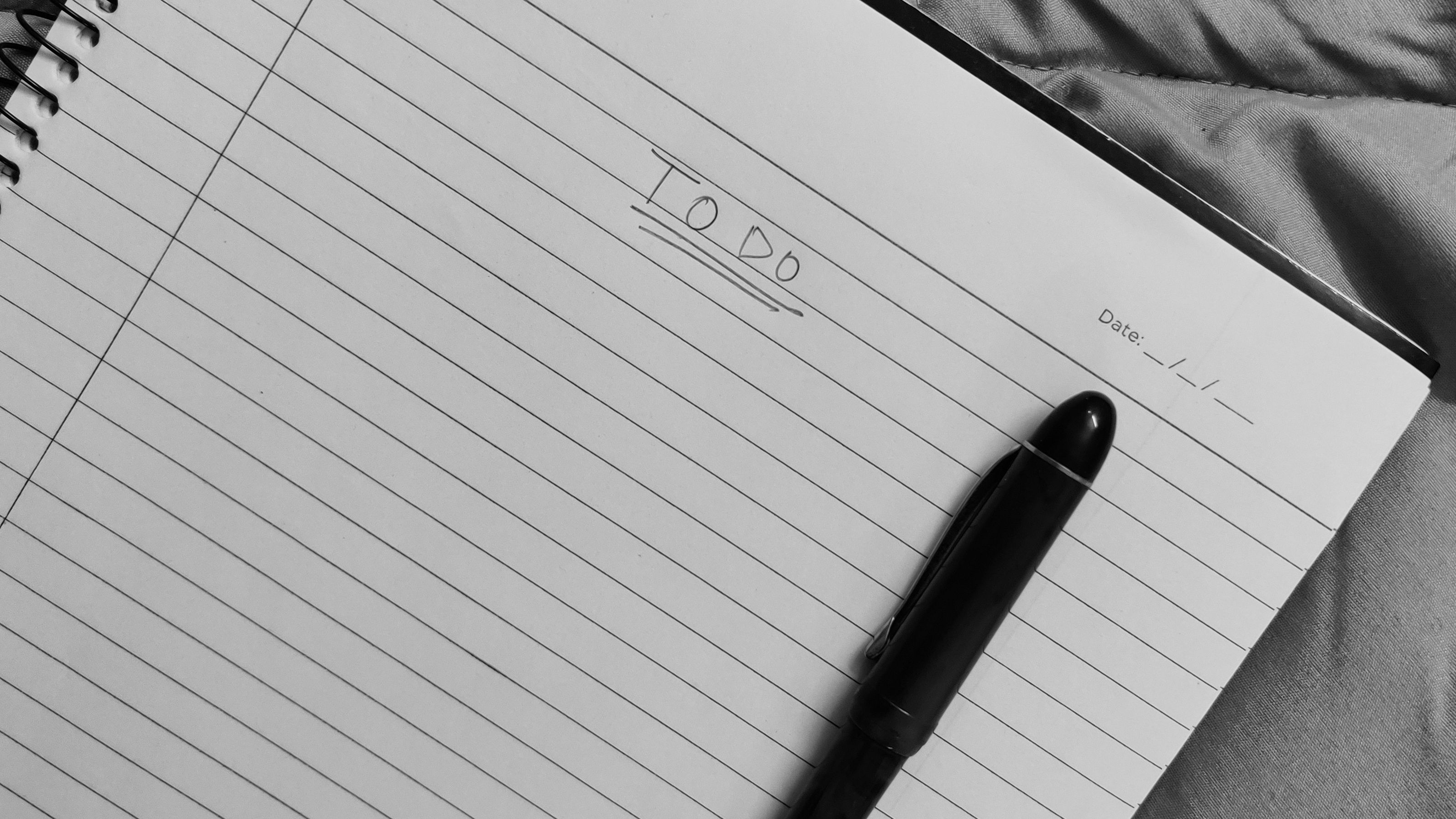 A notebook on a desk with a single line written on the top of an otherwise blank page