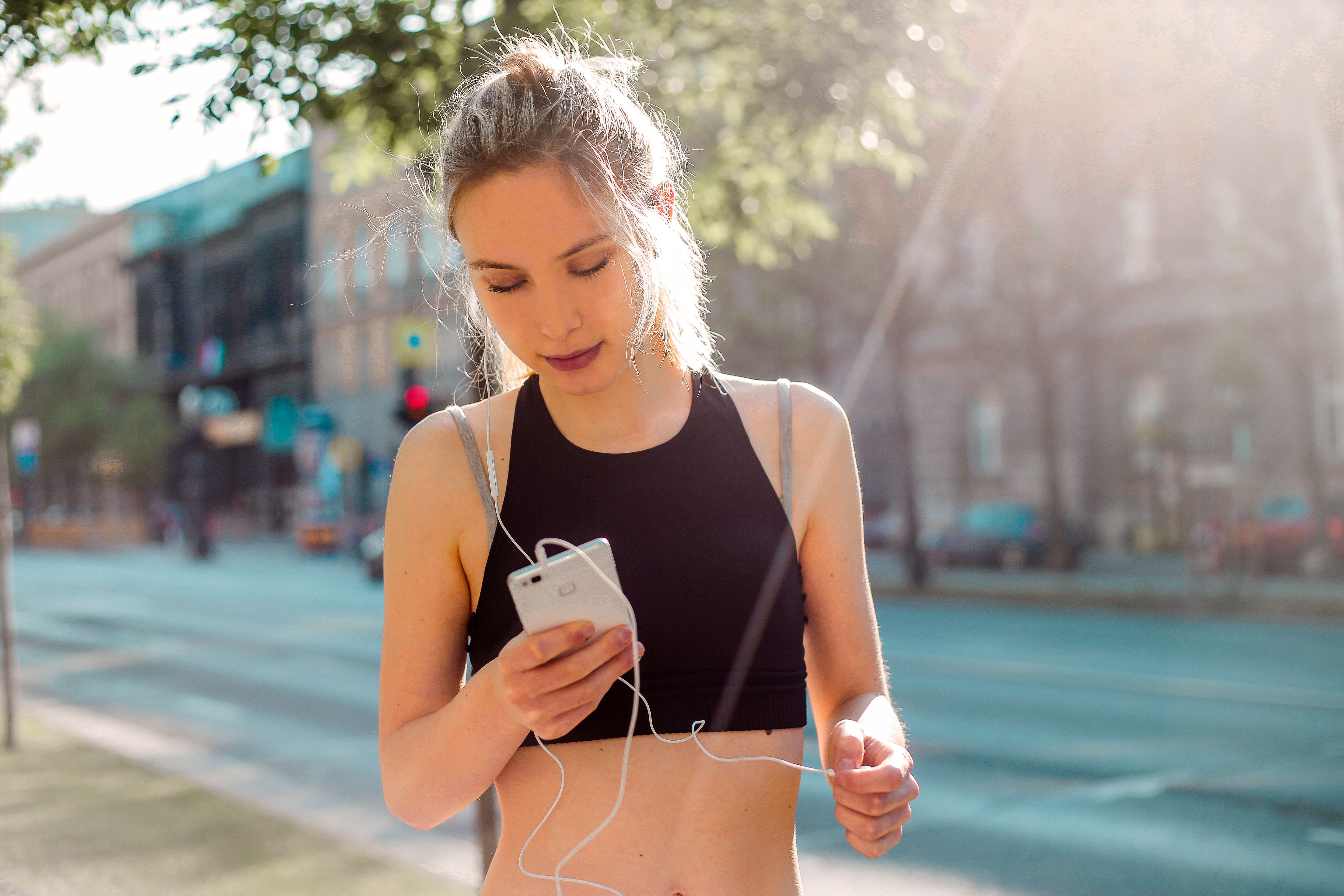 A person outdoors after a workout, on a phone call, midday light